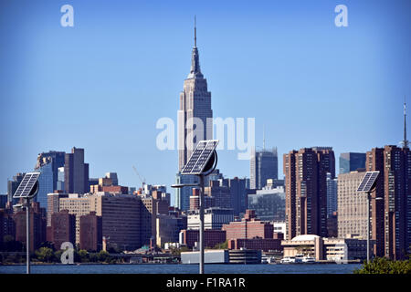 Des panneaux solaires dans l'East River State Park à Brooklyn, New York en vue de Manhattan et l'Empire State Building en arrière-plan. Banque D'Images