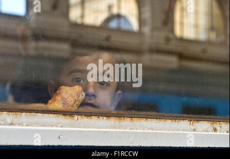 Budapest, Hongrie. 06 Sep, 2015. Un garçon regarde par la fenêtre d'un train avant le départ pour la frontière autrichienne à la gare de l'est à Budapest, Hongrie, 06 septembre 2015. La situation à la station de train a facilité encore, mais les réfugiés continuent d'arriver dans la ville à partir de la frontière serbe. Photo : Boris Roessler/dpa/Alamy Live News Banque D'Images