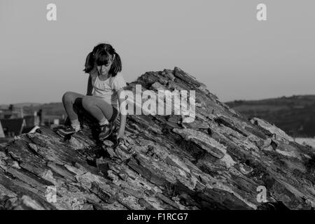 Pretty young girl climbing sur un rocher Banque D'Images