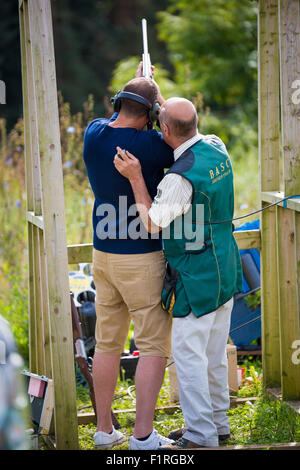 Un jeune homme le tir au pigeon d'argile avec un fusil de chasse à l'Beckbury Shropshire UK Show 2015 Banque D'Images