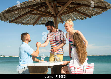 Groupe d'amis de vous détendre dans le bar de la plage Banque D'Images