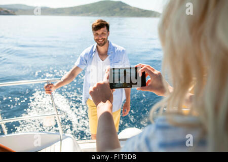 Young woman taking photo sur voilier, Mer Adriatique Banque D'Images