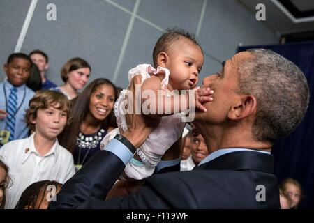 Le président des États-Unis, Barack Obama, est titulaire d'un bébé lors d'une Rencontre et accueil de l'ambassade des Etats-Unis le 8 avril 2015 à Kingston, Jamaïque. Banque D'Images