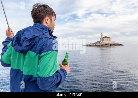 Man holding beer sur voilier, Mer Adriatique Banque D'Images