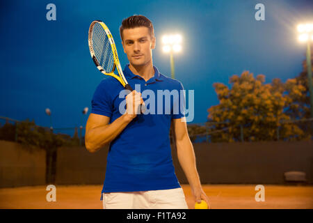 Portrait d'un beau mâle joueur tennis racket permanent avec l'extérieur et looking at camera Banque D'Images