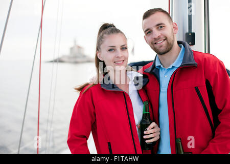 Jeune couple en train de boire une bière sur le voilier, Mer Adriatique Banque D'Images