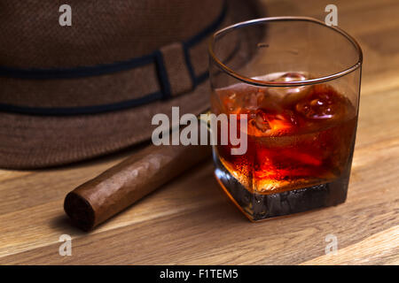 Whisky avec glace et de cigare, sur une vieille table en bois Banque D'Images