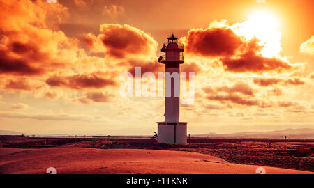 Une vue sur le phare d'El Fangar, dans le Delta de l'Ebre, en Espagne, au coucher du soleil dans un ciel nuageux Banque D'Images