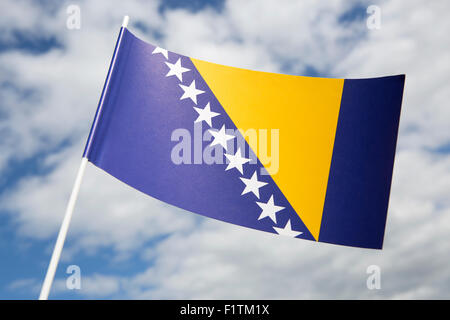 Bosnie-Herzégovine drapeau en face d'un ciel bleu Banque D'Images