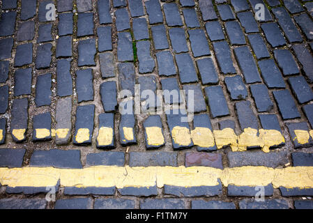 Les lignes jaunes double peint sur route pavée. Kelso, Ecosse Banque D'Images