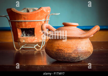 Pot en argile et cuisinière sur une table en bois. Banque D'Images