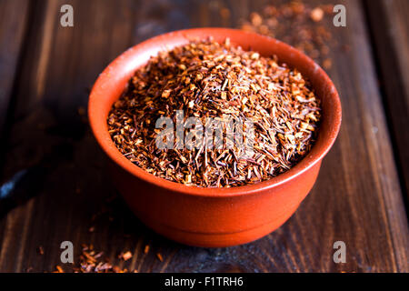 Rooibos séché Bol en céramique dans plus de fond de bois, lumière naturelle Banque D'Images