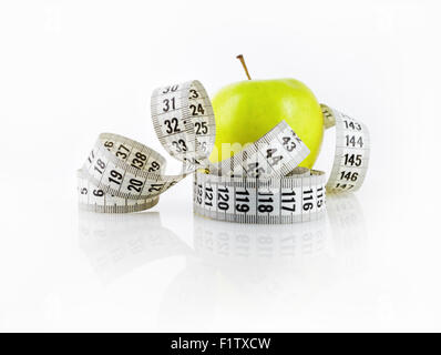 Pomme verte fraîche et ruban à mesurer. Symbole de l'alimentation et mode de vie sain. Profondeur de champ. L'accent sur le ruban à mesurer. Banque D'Images