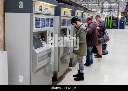 Les passagers d'acheter les billets de train à un ticket machine automatique sur la plate-forme, la gare centrale de Glasgow, Glasgow Ecosse Banque D'Images