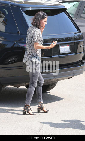 Make up gratuitement 'amis' star, Courteney Cox sort de son géant Range Rover et atterrit sur les deux pieds tout en discutant avec son téléphone portable. Elle vérifie ensuite son reflet dans le SUV poli comme elle arrive dans un studio à Los Angeles avec Courteney Cox : où : Los Angeles, California, United States Quand : 07 Juil 2015 Banque D'Images