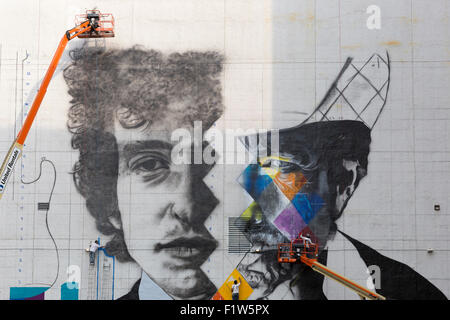 Artiste Eduardo Kobra et son équipe de cinq artistes travaillant sur les ascenseurs peinture une peinture murale de Bob Dylan en centre-ville de Minneapolis Banque D'Images