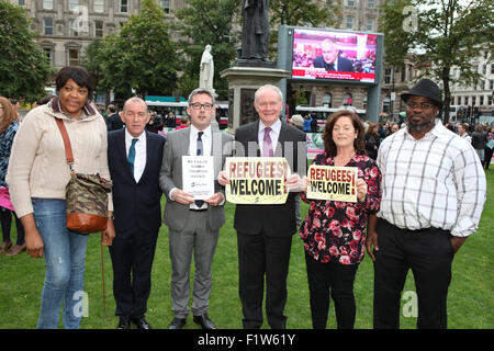 Belfast, en Irlande du Nord, Royaume-Uni. Août 30, 2015., UK.Vice-premier ministre Martin McGuinness (4e de gauche), Niall ' Donnghaile (3e de gauche) Justin Kouame (droite) était présent dans la foule où Lord Mayor Arder Carson (2e à gauche), Justin Kouame de NI communauté de réfugiés et Rosamund Bennett, Christian Aid, s'est adressé à la foule à Belfast City Hall vigile. Credit : Bonzo/Alamy Live News Banque D'Images