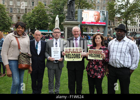 Belfast, en Irlande du Nord, Royaume-Uni. 30Th Aug 2015.Vice-premier ministre Martin McGuinness (4e de gauche), Niall ' Donnghaile (3e de gauche) Justin Kouame (droite) était présent dans la foule où Lord Mayor Arder Carson (2e à gauche), Justin Kouame de NI communauté de réfugiés et Rosamund Bennett, Christian Aid, s'est adressé à la foule à Belfast City Hall vigile. Credit : Bonzo/Alamy Live News Banque D'Images