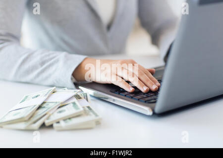 Close up of woman les mains avec de l'argent et l'ordinateur portable Banque D'Images