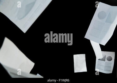 Les papiers d'affaires tomber sur fond noir Banque D'Images