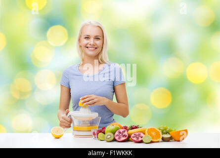 Smiling woman squeezing jus de fruits Banque D'Images