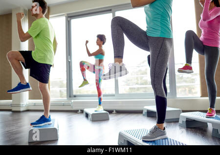 Groupe de gens qui élèvent les jambes sur les plates-formes étape Banque D'Images