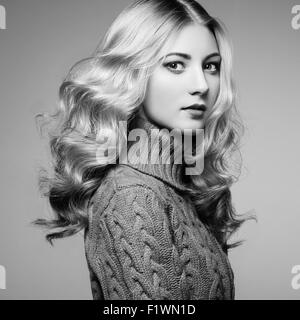 Photo de Mode de belle femme chandail. Curly hairstyle. Make-up. Le noir et blanc Banque D'Images