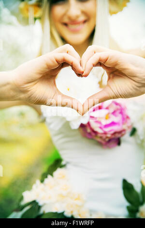 Belle femme joyeuse de faire le signe du coeur Banque D'Images