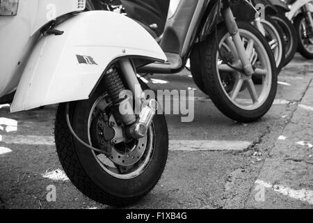 Ischia, Italie - 15 août 2015 : Classic style vieux peuplements scooters Vespa garé sur l'accotement, fragment avec roues avant Banque D'Images