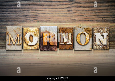 Le mot 'MORMON' écrit en métal rouillé type letterpress assis sur un rebord en bois, arrière-plan. Banque D'Images