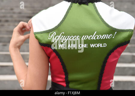 Munich, Allemagne. Sep 8, 2015 dpa-exclusif ?. Maria Pia modèle Buchmeier (dans Tian van Tastique) pose avec les mots 'réfugiés bienvenue ! Nous sommes un monde' sur le dos, sur les marches de la statue de la Bavière pendant l'Dirndlgipfel (dirndl sommet) à Munich, Allemagne, le 8 septembre 2015. Chaque année, les concepteurs de dirndl organiser une séance photo avec des modèles ou des célébrités et montrer les derniers à la mode traditionnelle pour le plus grand festival de musique folklorique, l'Oktoberfest, qui commence cette année le 19 septembre 2015. PHOTO : FELIX HOERHAGER/DPA/Alamy Live News Banque D'Images