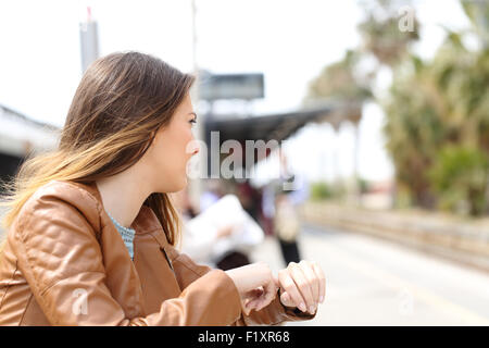 Fille en colère en attente dans une gare et à la gare de Banque D'Images