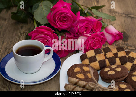 Bouquet de belles roses, divers témoins sur une assiette et café Banque D'Images