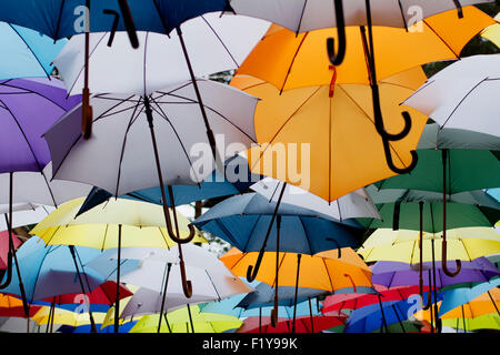 Parasols colorés suspendus dans la rue faire de street art intéressant. C'est un jour de pluie. Banque D'Images