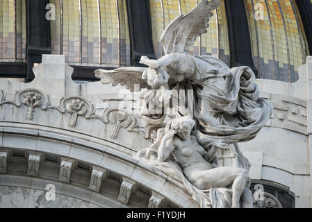 MEXICO CITY, Mexique — des figures sculpturales ornées représentant la musique et les arts ornent le fronton au-dessus de l'entrée principale du Palacio de Bellas Artes, illustrant les éléments de conception élaborés de style néo-classique et Art nouveau du bâtiment. Ces sculptures décoratives illustrent l'ornementation architecturale détaillée qui caractérise le premier centre culturel du Mexique. Le programme sculptural ajoute à la grandeur de la façade principale du palais. Banque D'Images