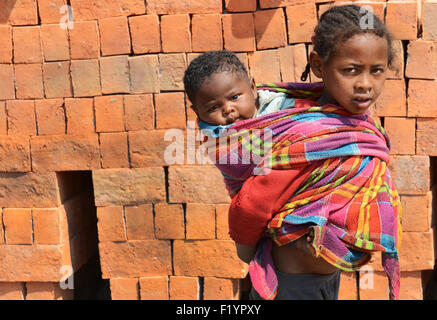 Frères et sœurs malgaches à une fabrique de brique rurale dans le centre de Madagascar. Banque D'Images