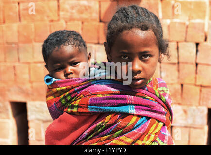 Frères et sœurs malgaches à une fabrique de brique rurale dans le centre de Madagascar. Banque D'Images