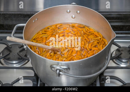 Panneaux oranges pelées dans un métal chauffage préservant le moule sur une cuisinière à gaz en préparation à ébullition pour faire de la marmelade faite maison Banque D'Images