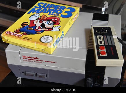 Berlin, Allemagne. Sep 8, 2015. Un 'Super Mario 3' jeu est sur le dessus d'une console de jeux NES des années 80, à Berlin, Allemagne, le 8 septembre 2015. Photo : Bernd Settnik/dpa/Alamy Live News Banque D'Images