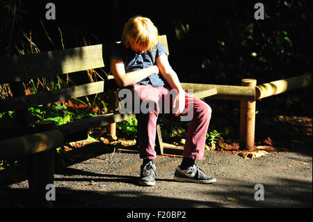 Sleeping boy on park bench Banque D'Images