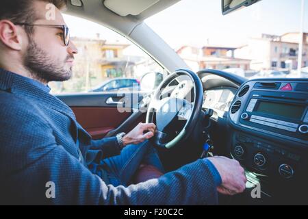 Jeune homme driving car Banque D'Images