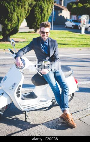 Portrait de jeune homme élégant sur cyclomoteur Banque D'Images