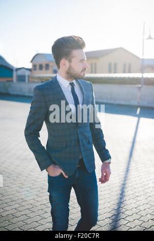 Jeune homme élégant walking with hand in pocket Banque D'Images