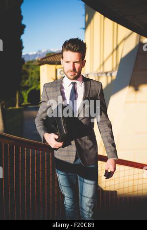 Young businessman carrying briefcase sur passerelle Banque D'Images