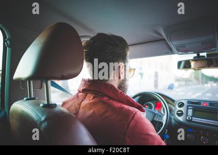 Vue arrière du jeune homme sur la route driving car Banque D'Images