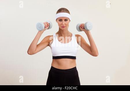 Portrait of woman lifting dumb bells Banque D'Images