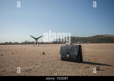 Mid adult businessman faisant la roue sur la plage Banque D'Images