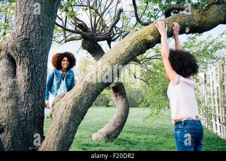 Mother smiling at Fille Arbre d'escalade Banque D'Images