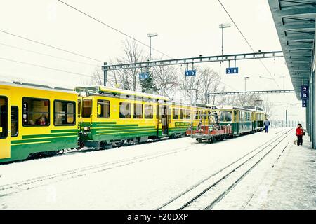 Les trains et les passagers dans la neige a couvert la gare, Wengen, Suisse Banque D'Images