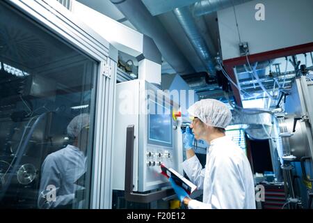 Male scientist avec panneau de réglage de l'ordinateur portable en salle blanche de laboratoire Banque D'Images